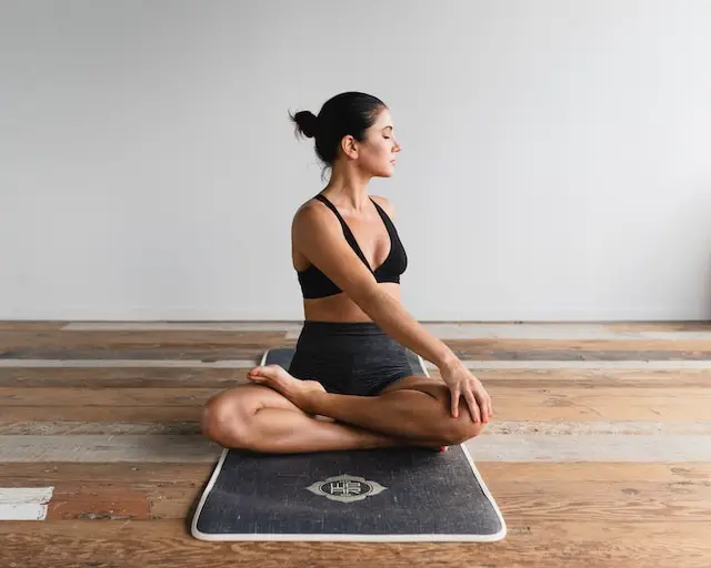 Woman doing yoga on a gray yoga mat